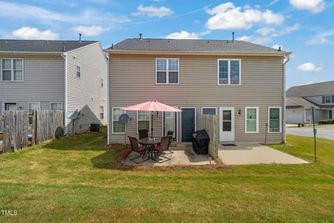 a view of a house with a yard patio and fire pit