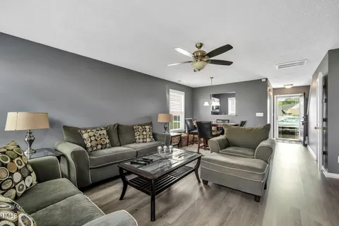 a living room with furniture and wooden floor