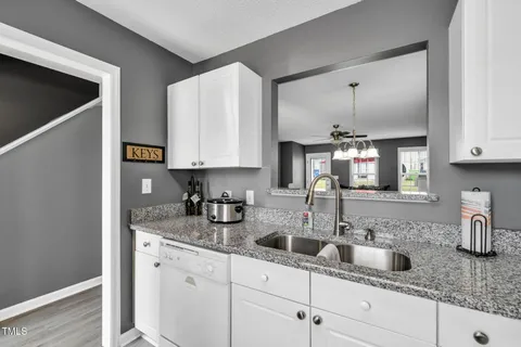 a kitchen with stainless steel appliances granite countertop a sink and a white cabinets