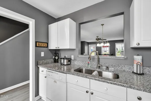 a kitchen with stainless steel appliances granite countertop a sink and a white cabinets