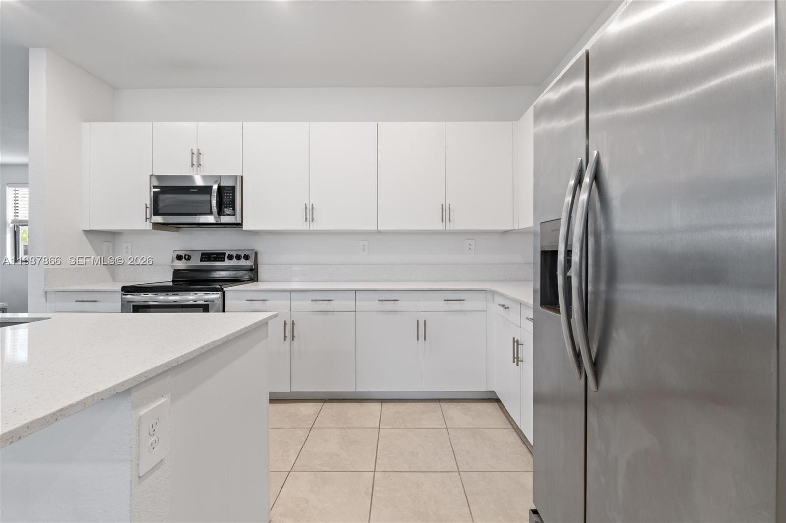 11903 Southwest 241st Street, Unit 11903 Homestead, FL 33032 - Photo 11 of 57 a kitchen with a refrigerator sink and cabinets