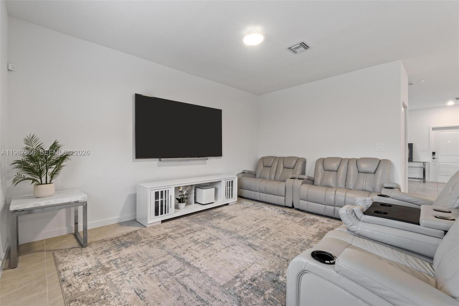 11903 Southwest 241st Street, Unit 11903 Homestead, FL 33032 - Photo 17 of 57 a living room with furniture and a flat screen tv
