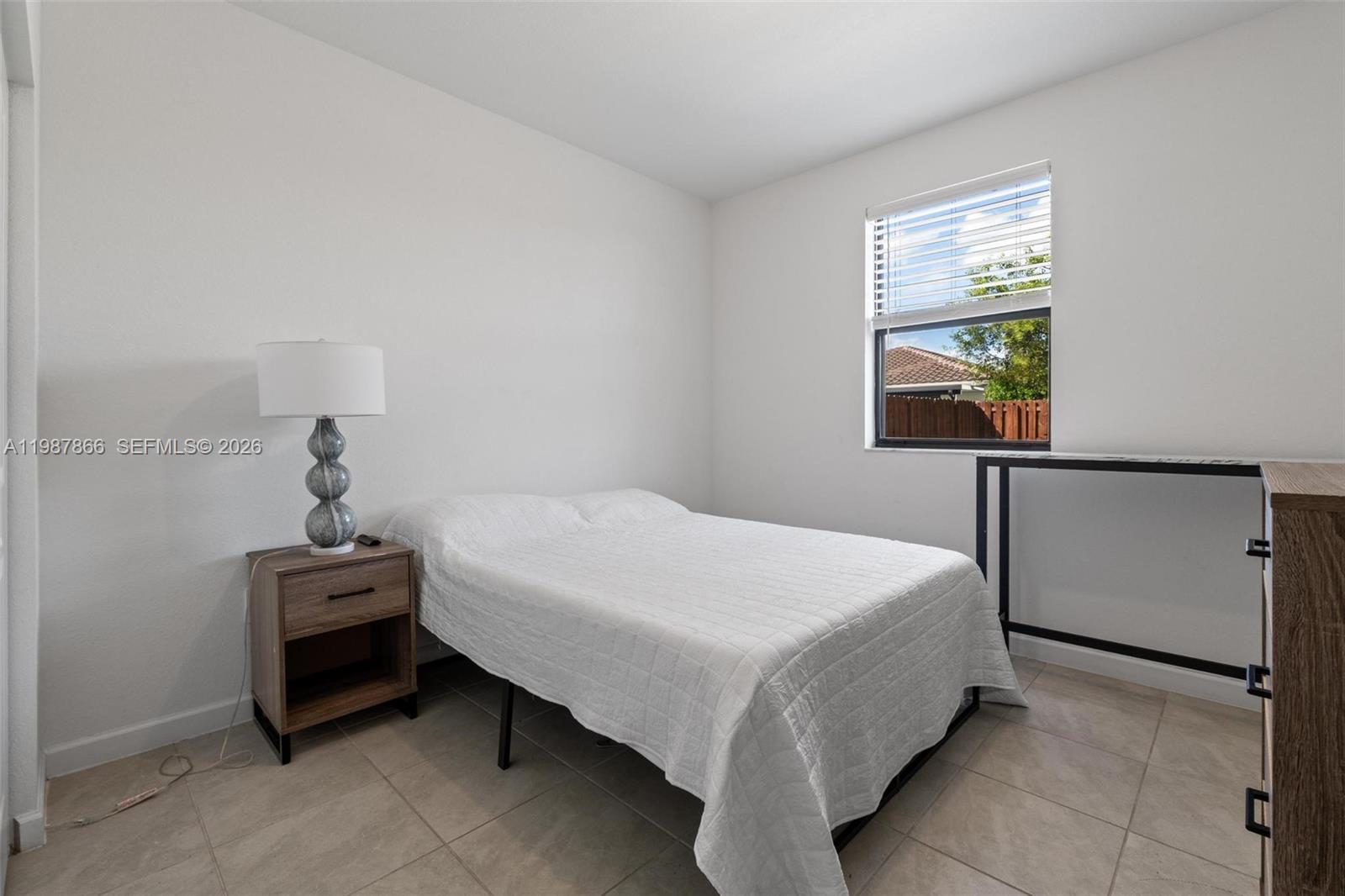 11903 Southwest 241st Street, Unit 11903 Homestead, FL 33032 - Photo 19 of 57 a bedroom with a bed and a window