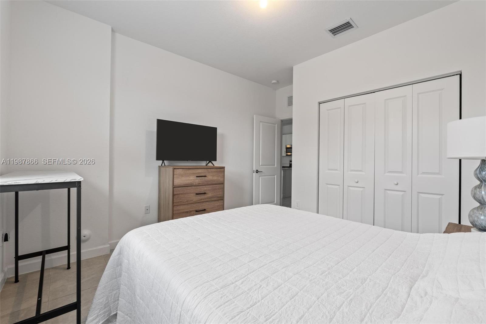 11903 Southwest 241st Street, Unit 11903 Homestead, FL 33032 - Photo 20 of 57 a bedroom with a bed and a flat screen tv