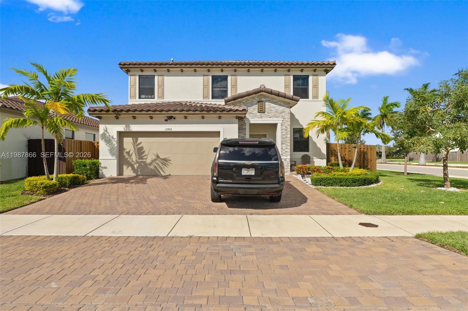 11903 Southwest 241st Street, Unit 11903 Homestead, FL 33032 - Photo 2 of 57 a front view of a house with a yard and a garage