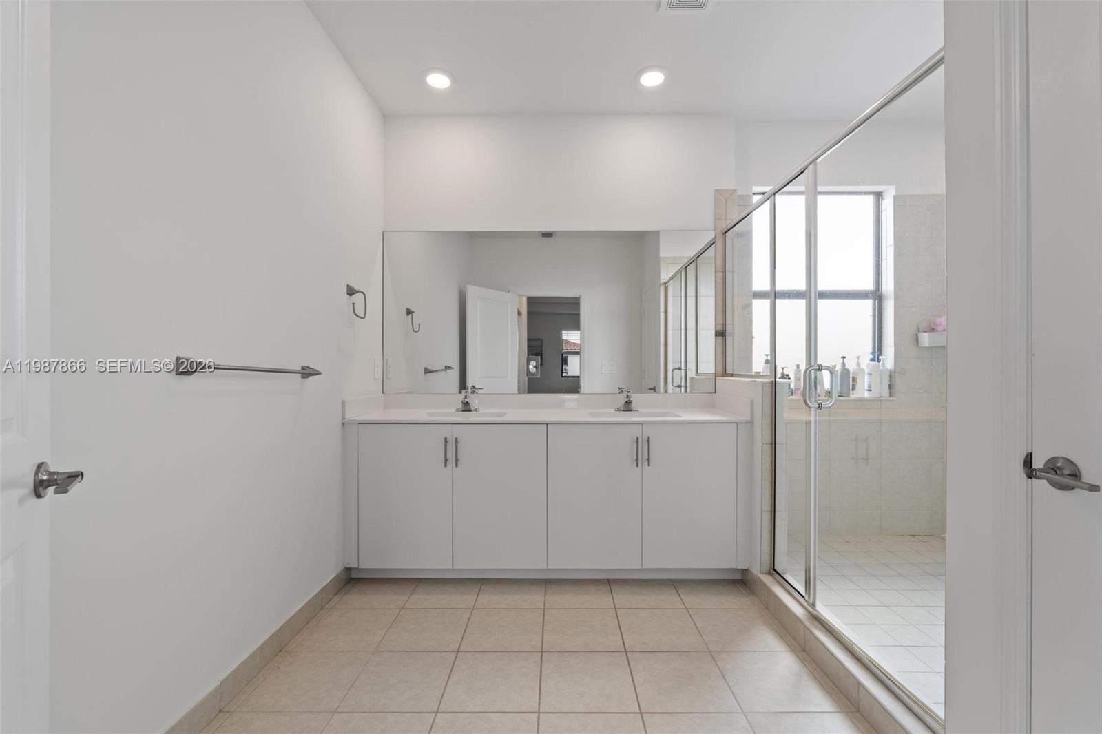 11903 Southwest 241st Street, Unit 11903 Homestead, FL 33032 - Photo 33 of 57 a bathroom with a sink a mirror and shower