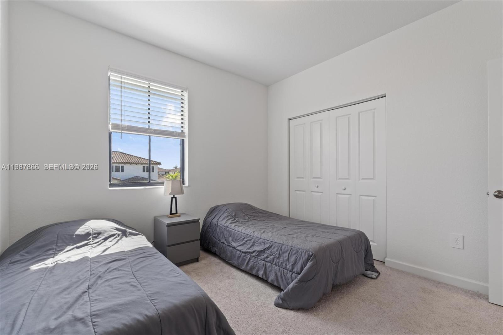 11903 Southwest 241st Street, Unit 11903 Homestead, FL 33032 - Photo 37 of 57 a bedroom with two beds and a window