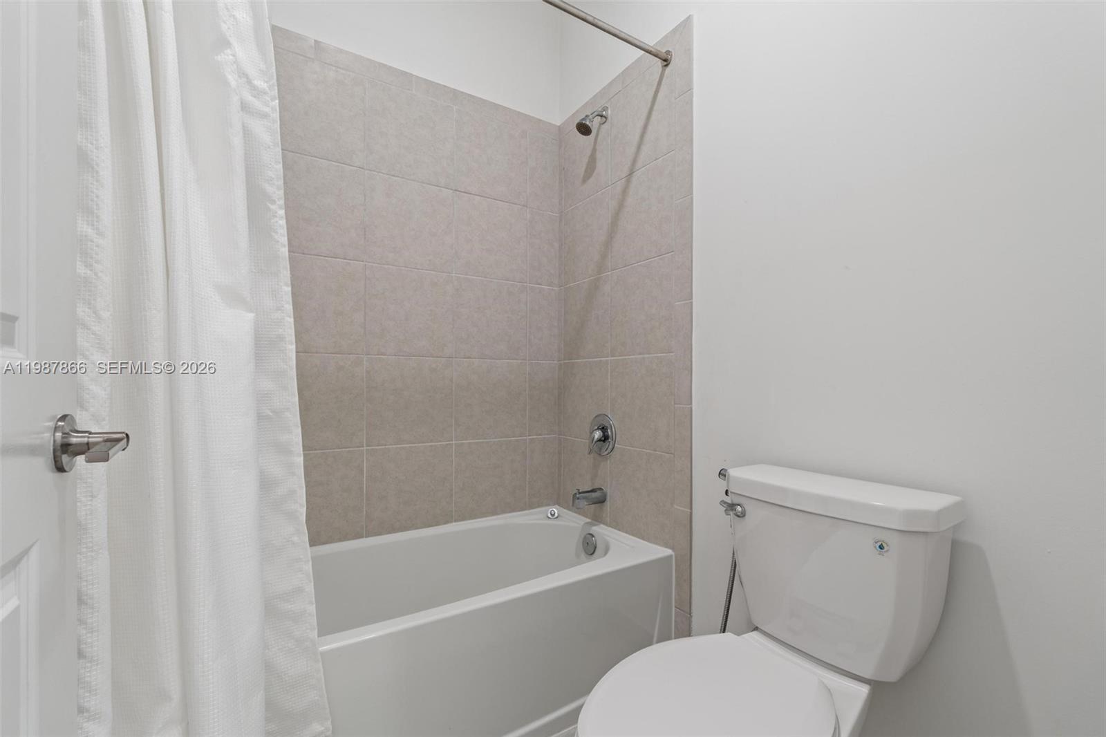 11903 Southwest 241st Street, Unit 11903 Homestead, FL 33032 - Photo 39 of 57 a white toilet sitting next to a bath tub