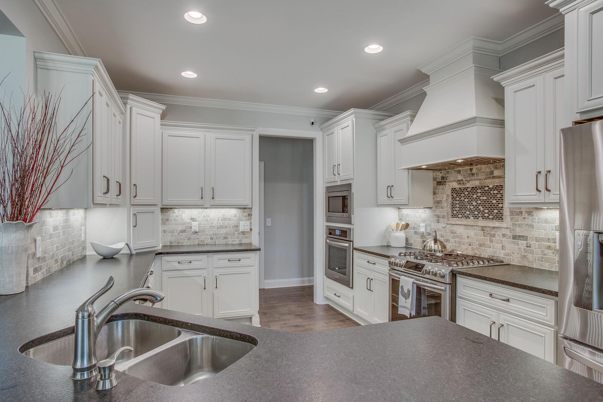 7901 Pinewood Road Fairview, TN 37062 - Photo 11 of 29 a kitchen with stainless steel appliances kitchen island granite countertop a sink stove and cabinets