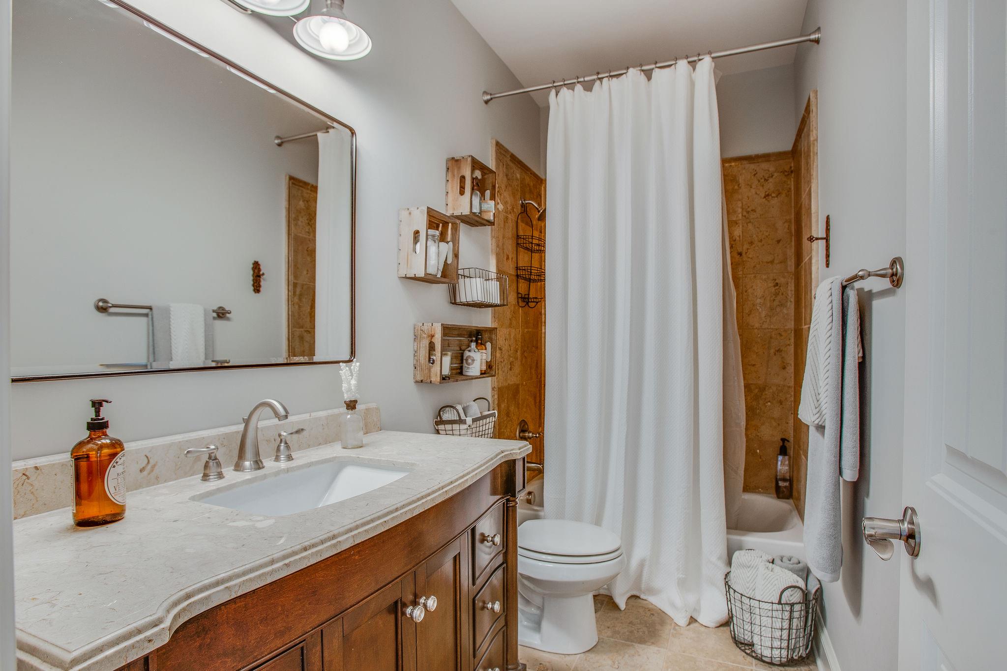 7901 Pinewood Road Fairview, TN 37062 - Photo 19 of 29 a bathroom with a granite countertop sink a toilet and shower