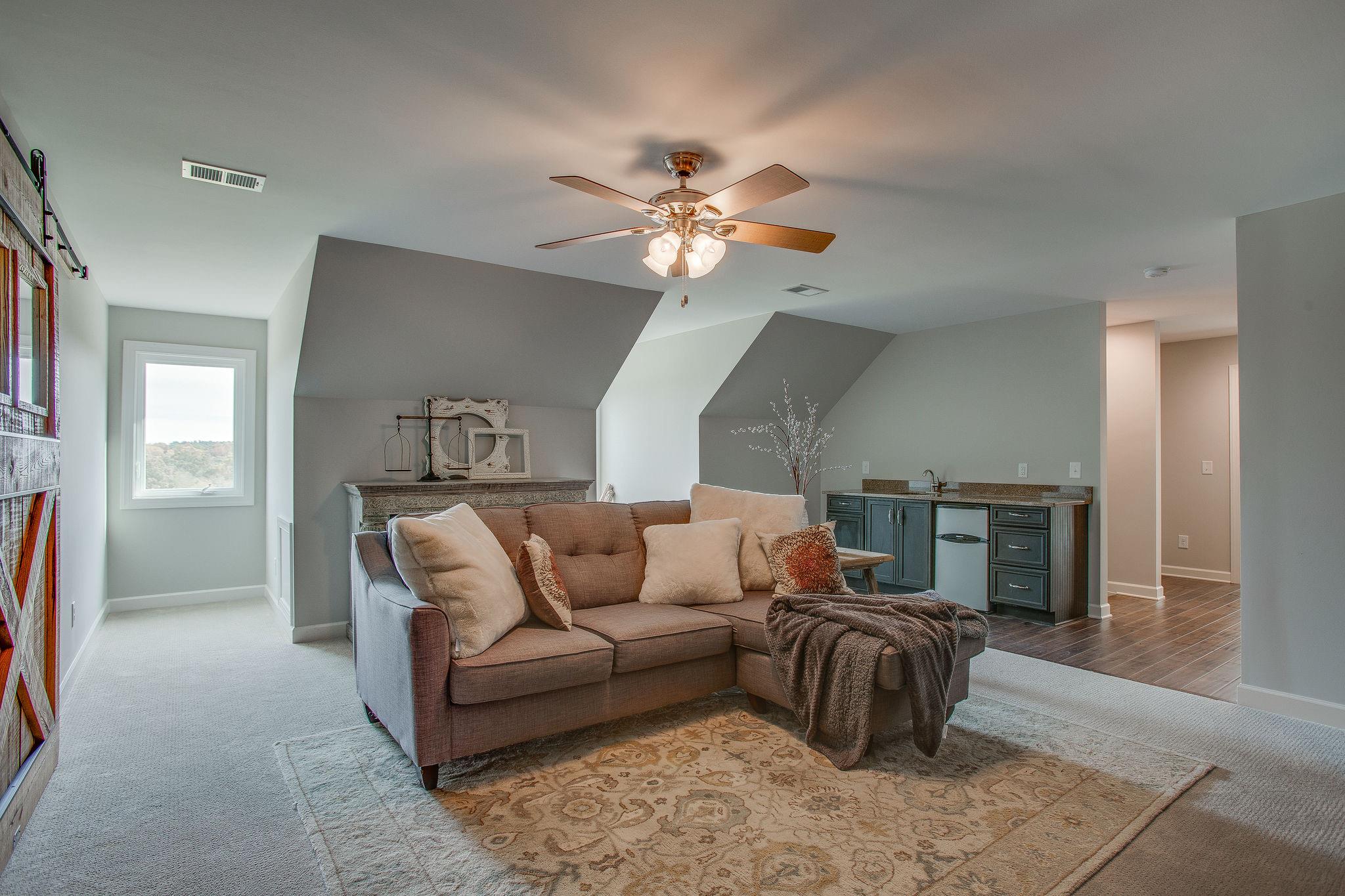7901 Pinewood Road Fairview, TN 37062 - Photo 21 of 29 a living room with furniture ceiling fan and a rug