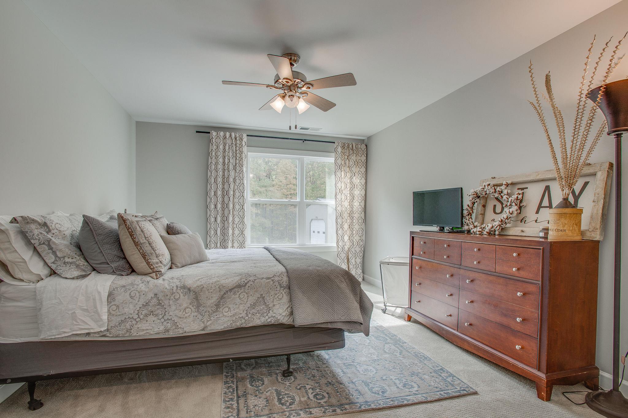 7901 Pinewood Road Fairview, TN 37062 - Photo 22 of 29 a bedroom with a large bed and a chandelier