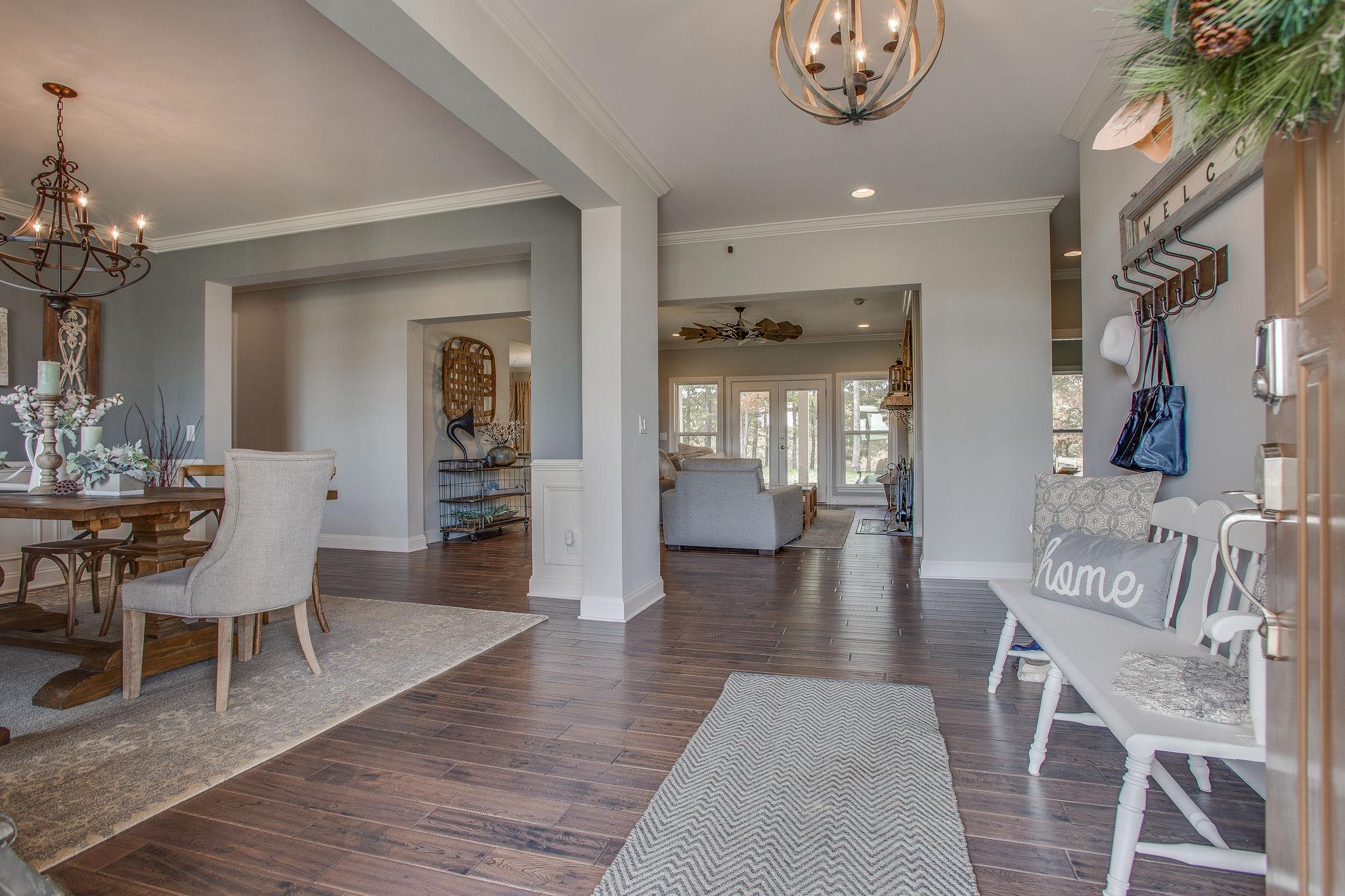 7901 Pinewood Road Fairview, TN 37062 - Photo 6 of 29 a dining room with wooden floor a chandelier a wooden table and chairs