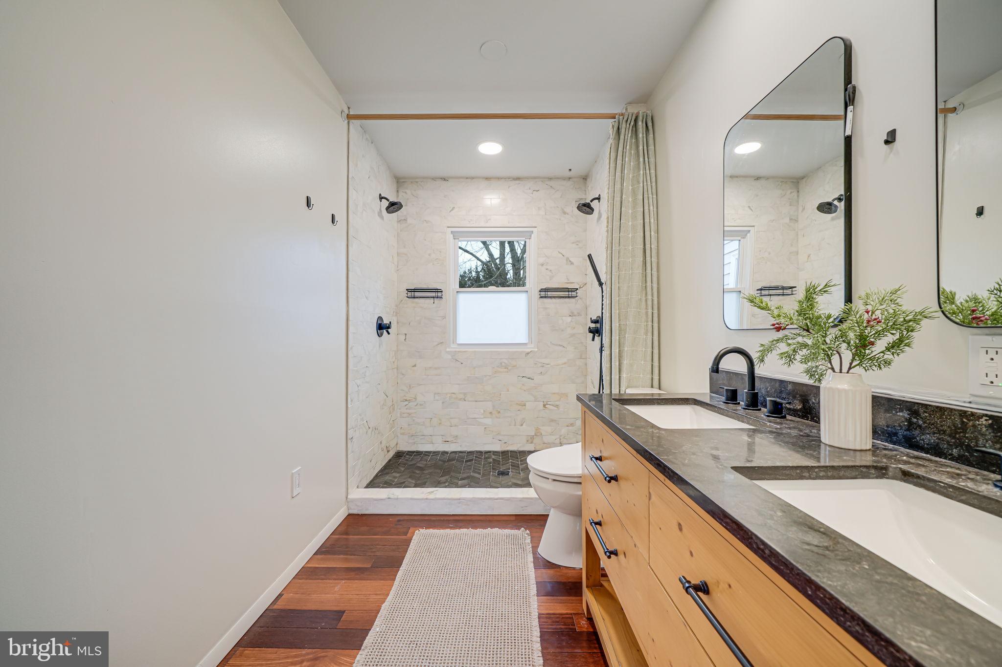 116 Elm Tree Lane Sterling, VA 20164 - Photo 34 of 56 a bathroom with a sink a large mirror and a shower