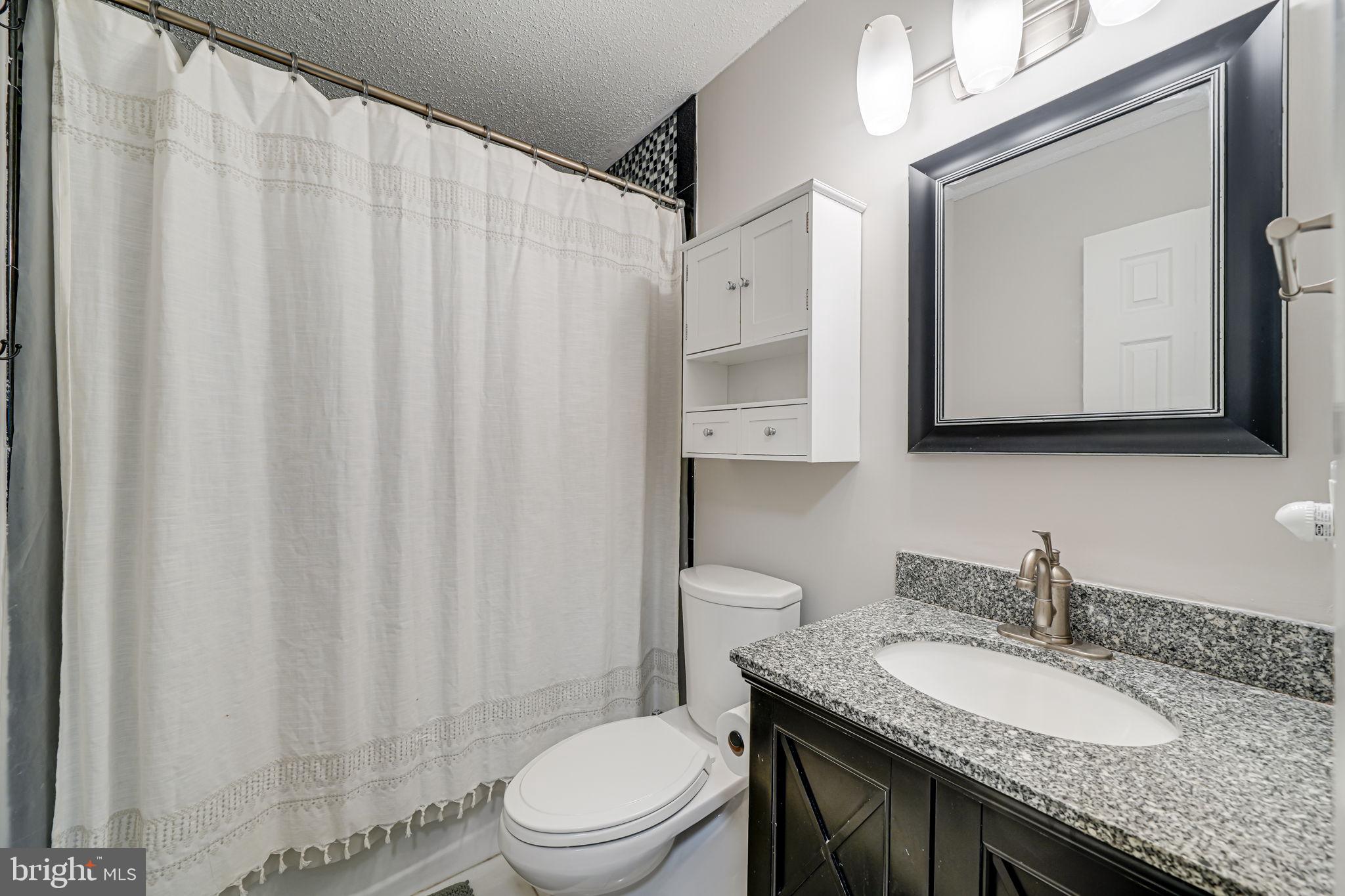 116 Elm Tree Lane Sterling, VA 20164 - Photo 43 of 56 a bathroom with a granite countertop sink vanity mirror and toilet