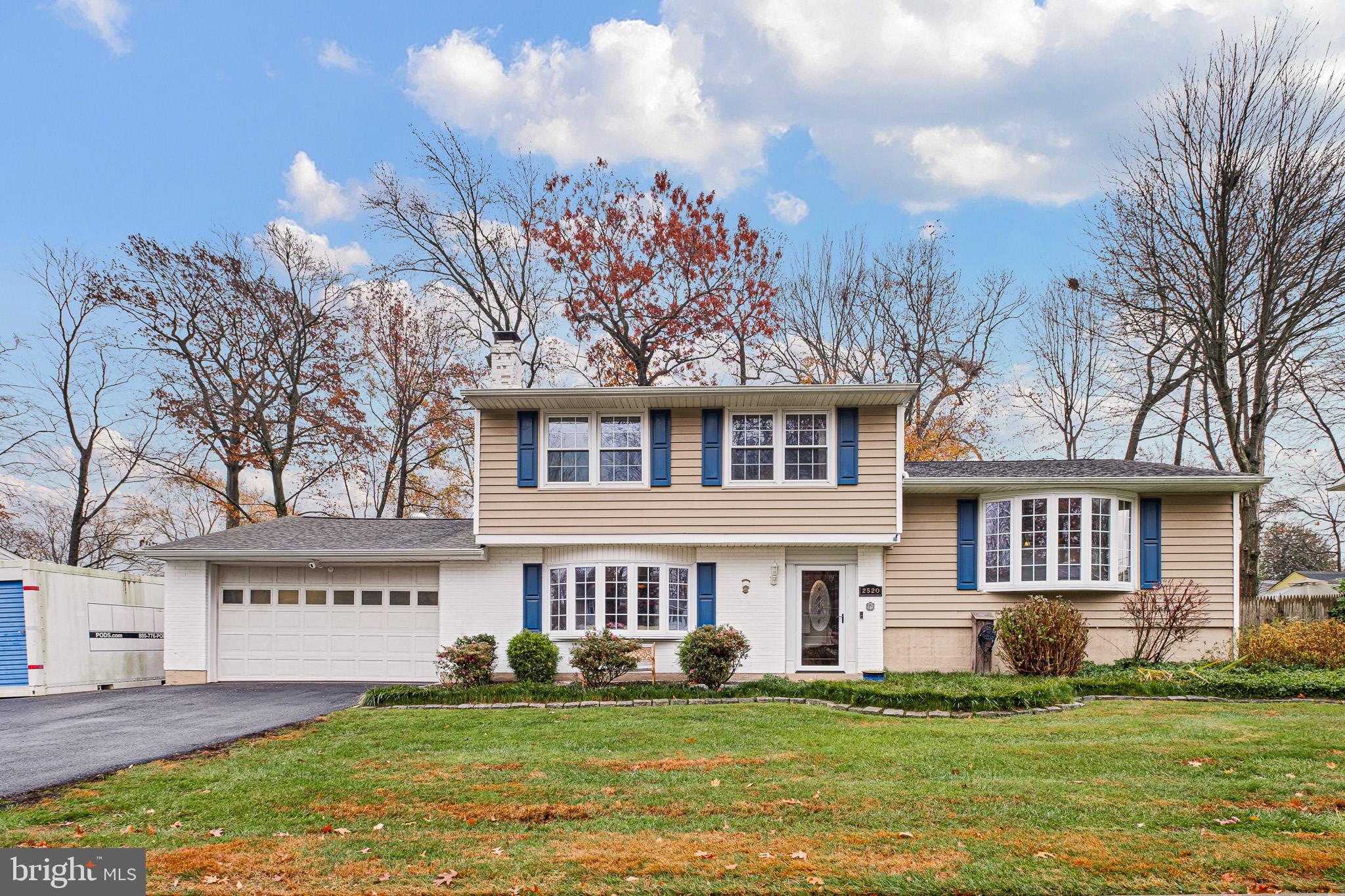 a view of a house with a big yard and large trees