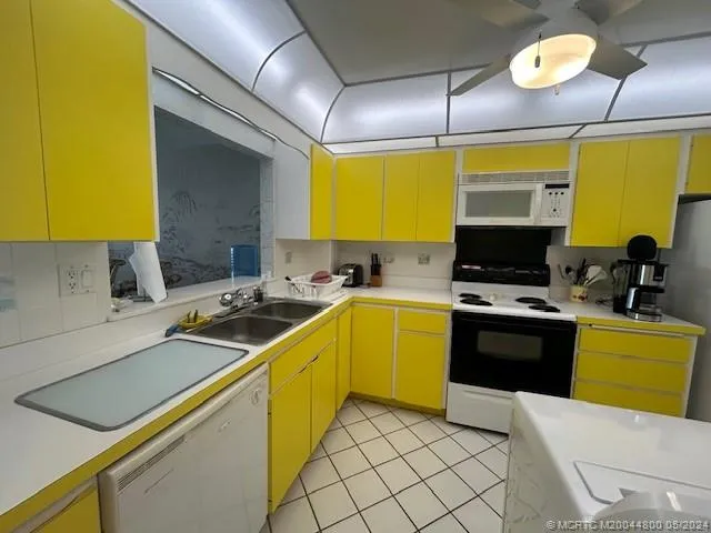a kitchen with a sink a stove cabinets and a counter top space