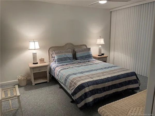 a bedroom with a bed a mirror and windows