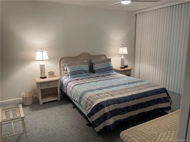 a bedroom with a bed a mirror and windows