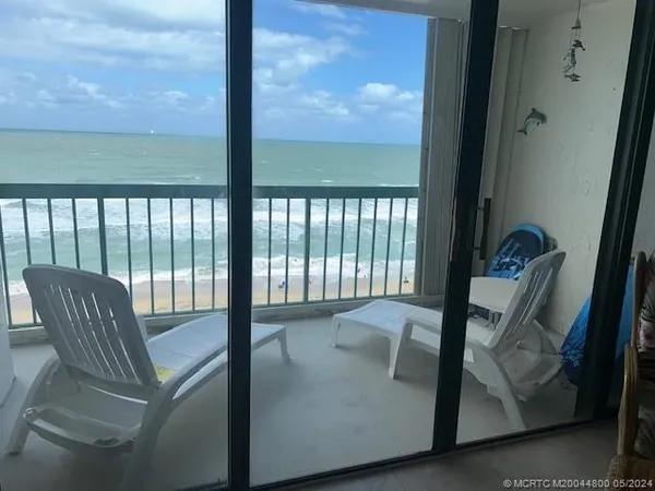 a view of a hallway with chairs and a potted plant