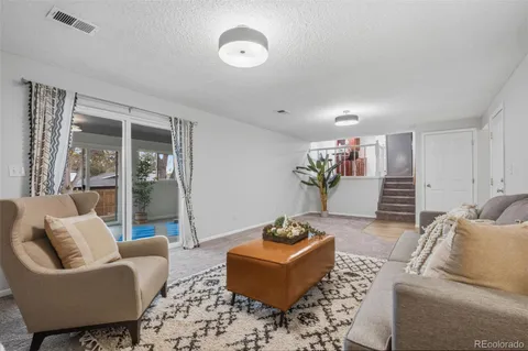 a living room with furniture and a potted plant