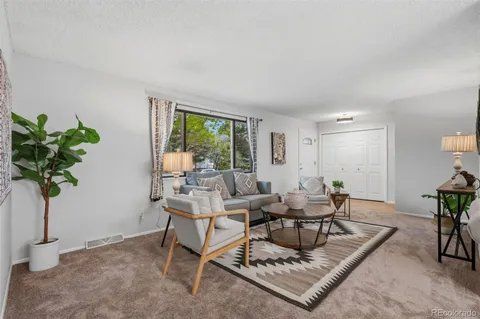 a living room with furniture and a potted plant