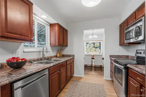 a kitchen with stainless steel appliances granite countertop a sink stove and cabinets