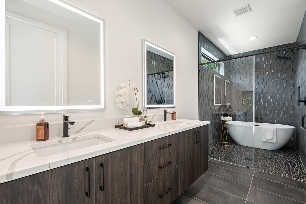 4407 Merle Drive, Unit B Austin, TX 78745 - Photo 23 of 38 a bathroom with a double vanity sink a large mirror and a bathtub