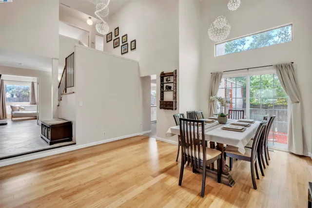 a dining room with furniture a chandelier and wooden floor