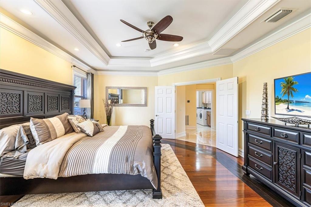 2135 Par Drive Naples, FL 34120 - Photo 18 of 49 a spacious bedroom with a bed a dresser and a flat screen tv