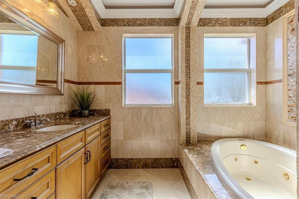 2135 Par Drive Naples, FL 34120 - Photo 23 of 49 a bathroom with a granite countertop sink and a bathtub