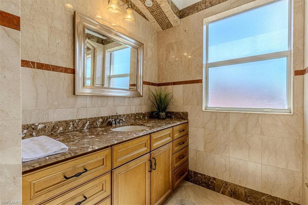 2135 Par Drive Naples, FL 34120 - Photo 25 of 49 a bathroom with a sink a vanity and mirror