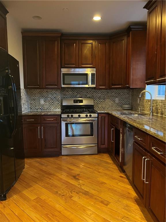 a kitchen with stainless steel appliances granite countertop wooden cabinets stove top oven and sink