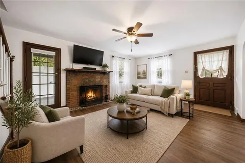 a living room with furniture a flat screen tv and a fireplace