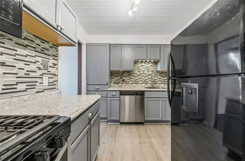 a kitchen with stainless steel appliances granite countertop a stove and a refrigerator