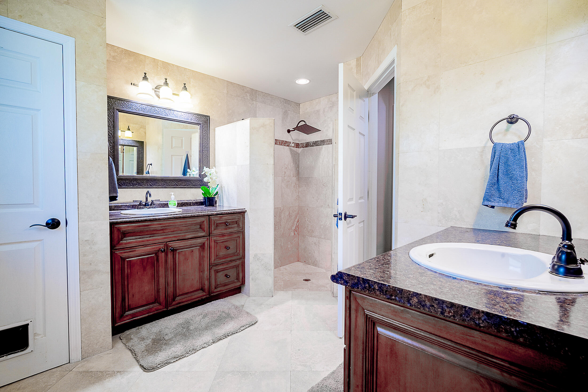 5512 Southeast Nassau Terrace Stuart, FL 34997 - Photo 15 of 24 a spacious bathroom with a granite countertop sink and a mirror