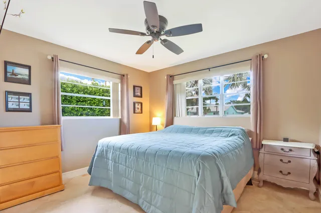 a bed sitting in a spacious bedroom next to a window