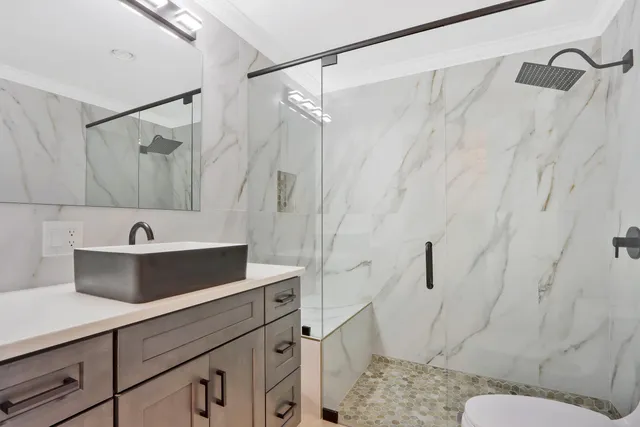 a bathroom with a sink a toilet and shower