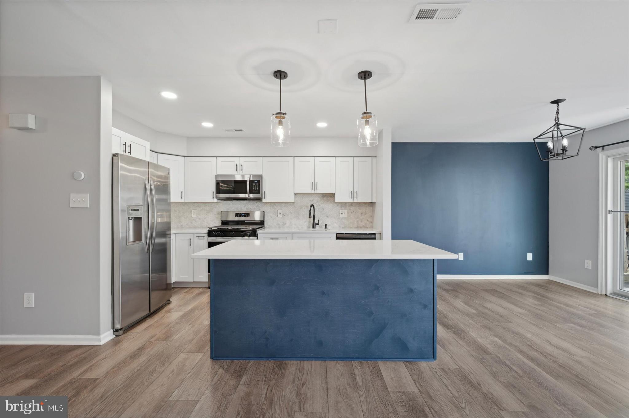 9 Meadow Lane Delran, NJ 08075 - Photo 6 of 15 a large kitchen with stainless steel appliances a large counter top and a wooden floors