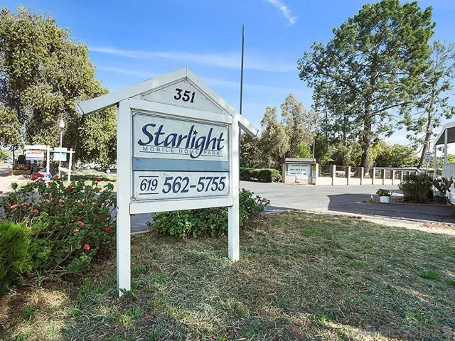 a view of a street sign under a large tree