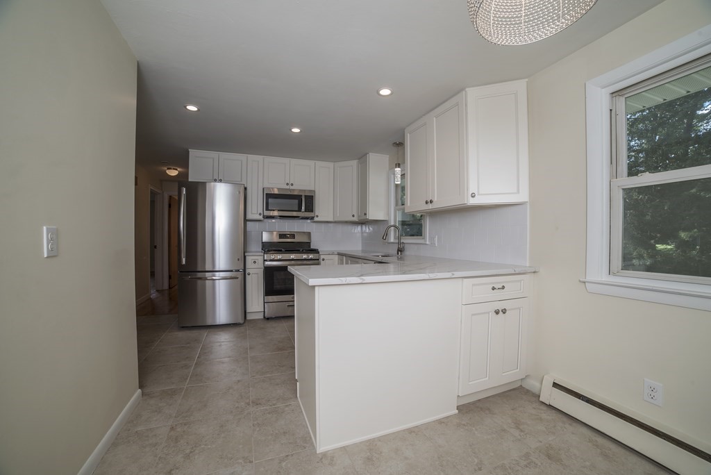 611 Allen Street Springfield, MA 01118 - Photo 20 of 37 a kitchen with white cabinets and stainless steel appliances