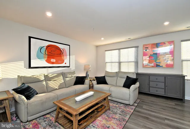 a living room with furniture a rug and a window