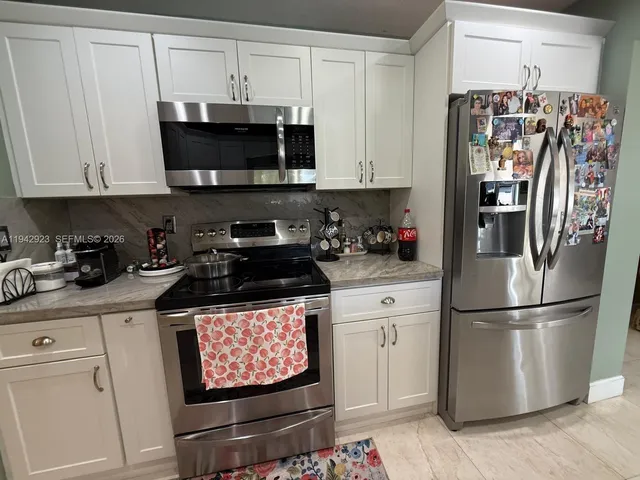 a kitchen with stainless steel appliances granite countertop a refrigerator sink and cabinets