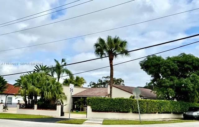a front view of a house with a yard and potted plants