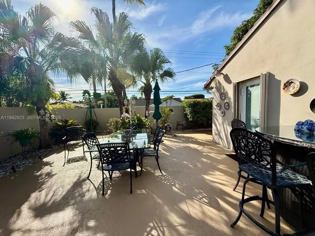a view of a patio with table and chairs and potted plants