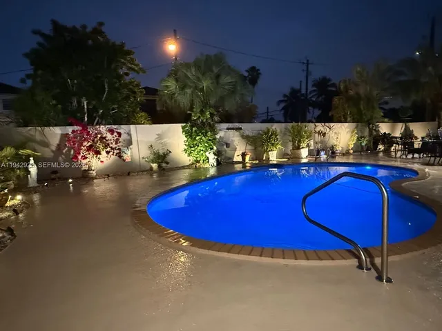 a view of a swimming pool with an outdoor seating and a kitchen