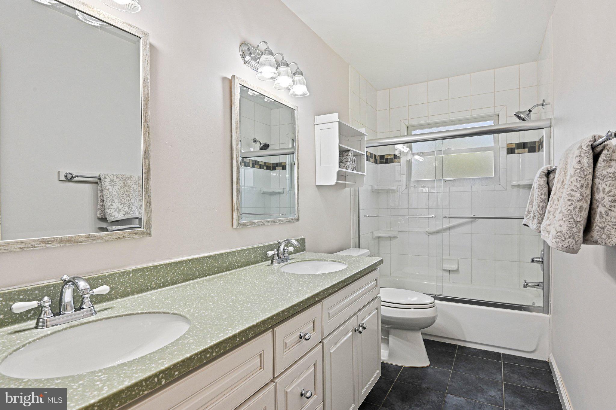 909 Plum Street Southwest Vienna, VA 22180 - Photo 23 of 38 a bathroom with a granite countertop sink a toilet a mirror and shower