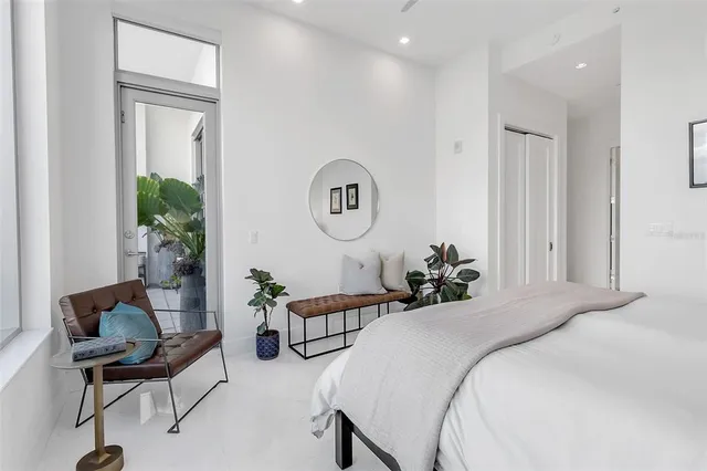 a spacious bedroom with a bed and a painting on the wall
