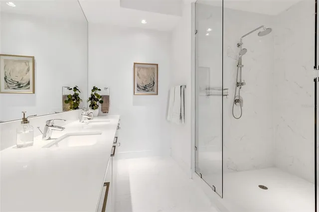 a bathroom with a double vanity sink mirror and shower