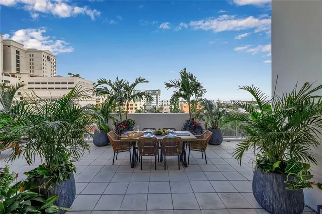 a view of outdoor dining space with furniture and potted plants